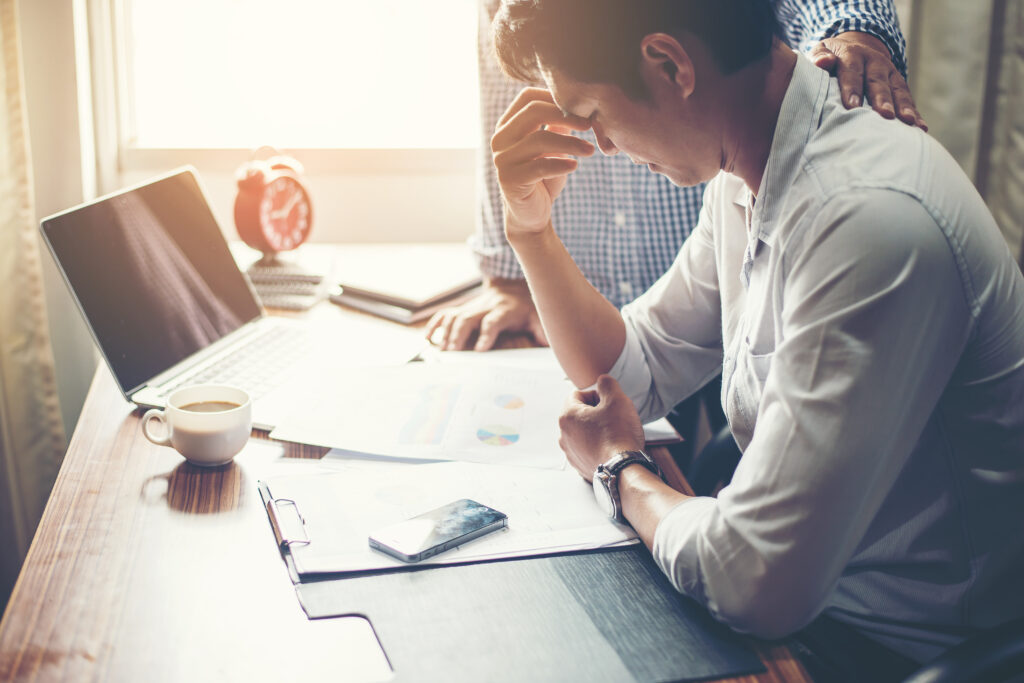 Serious young businessman looking at financial report seem like something mistake with his boss in office.